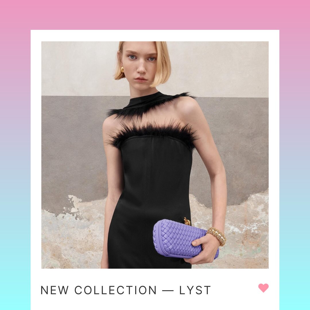 A model with short blonde hair showcasing a sleek black dress adorned with a feathered neckline detail, paired with a purple quilted clutch purse. 